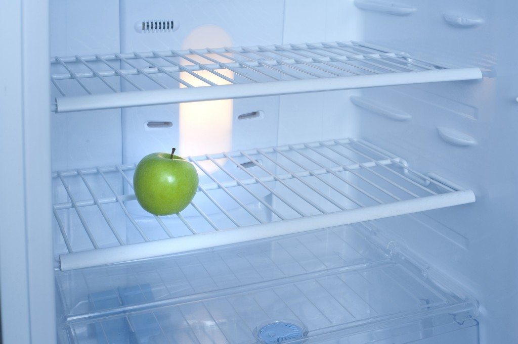 One green apple inside a fridge