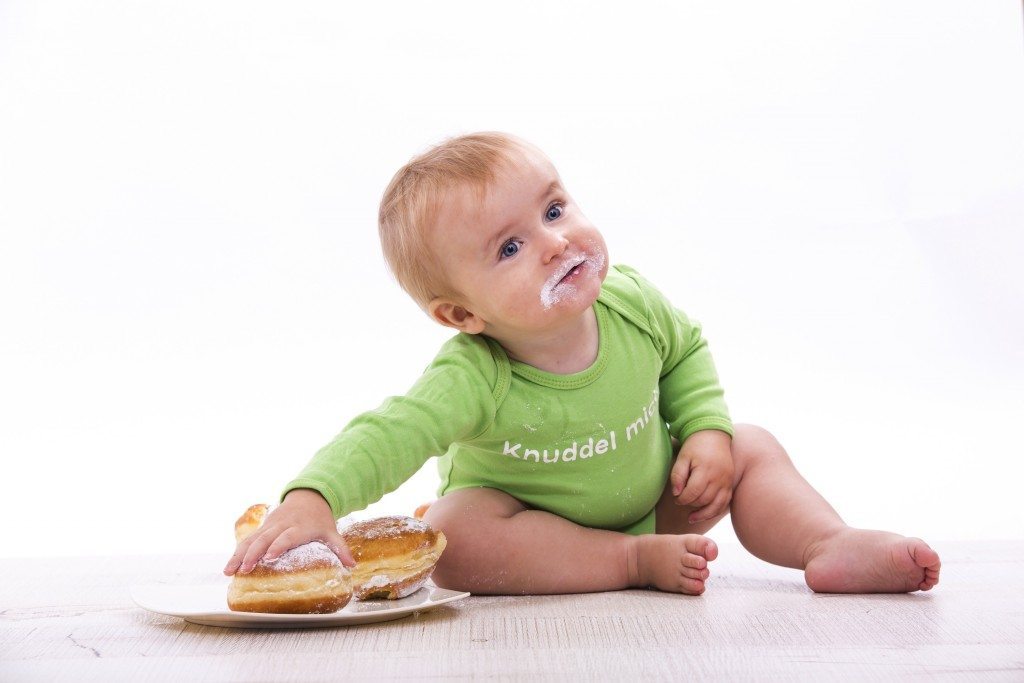 Kleiner Bub mit einem Krapfen