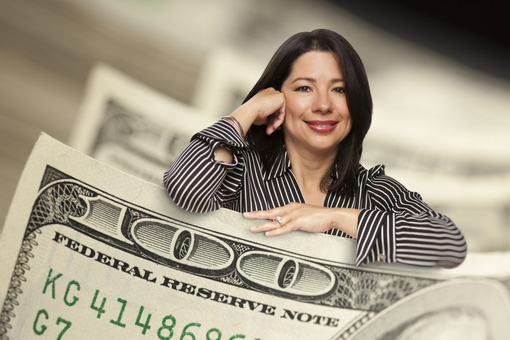 Attractive Hispanic Woman Leaning on a One Hundred Dollar Bill.