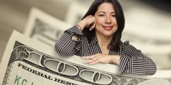 Attractive Hispanic Woman Leaning on a One Hundred Dollar Bill.